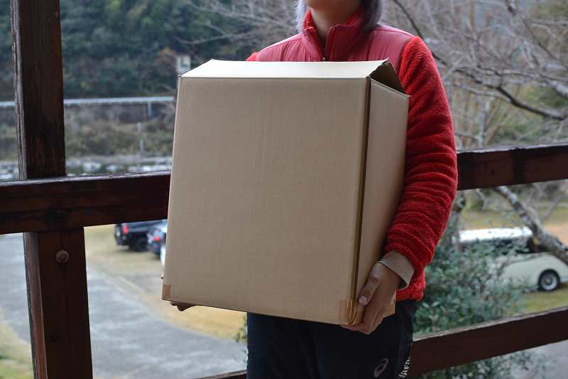 焚き付け用薪(10kg入り)を持ったところ